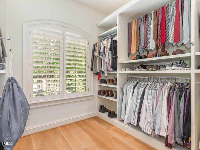 walk in closet with light hardwood / wood-style floors