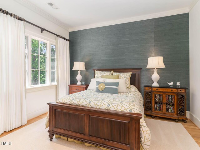 bedroom with light hardwood / wood-style flooring and ornamental molding