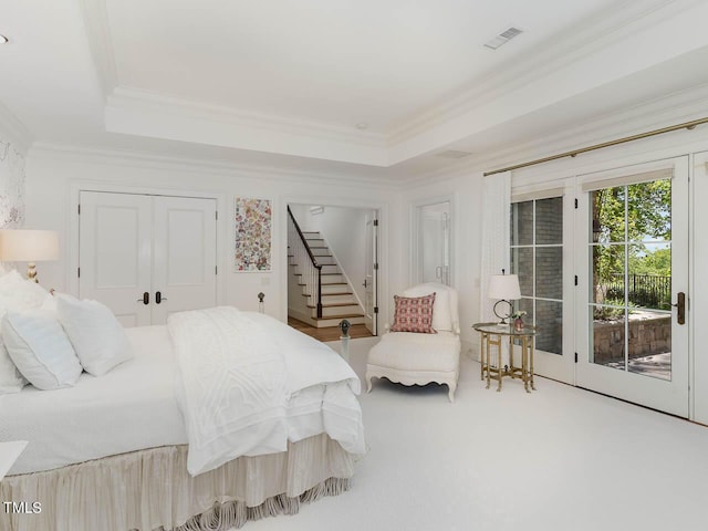 carpeted bedroom with access to outside, crown molding, and a raised ceiling