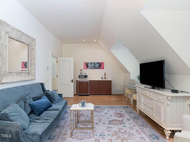 living room with lofted ceiling and light wood finished floors