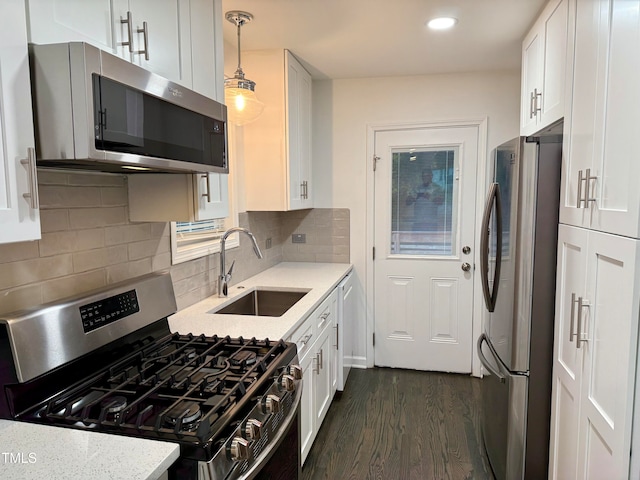 kitchen featuring sink, appliances with stainless steel finishes, decorative light fixtures, and white cabinets