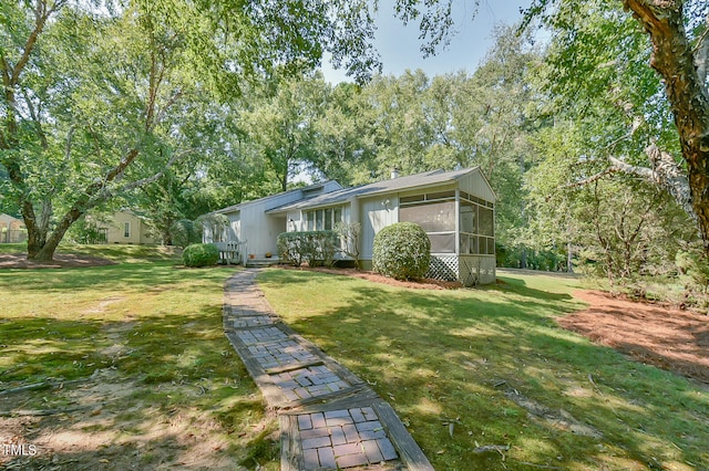 ranch-style house featuring a front yard and a sunroom