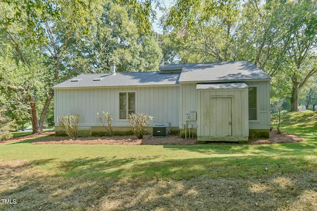 back of property with cooling unit and a lawn