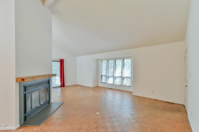 unfurnished living room featuring light parquet flooring and vaulted ceiling