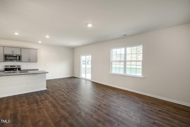 unfurnished living room featuring dark hardwood / wood-style floors and sink