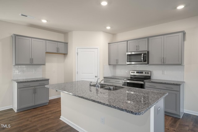 kitchen with appliances with stainless steel finishes, sink, dark wood-type flooring, and gray cabinetry