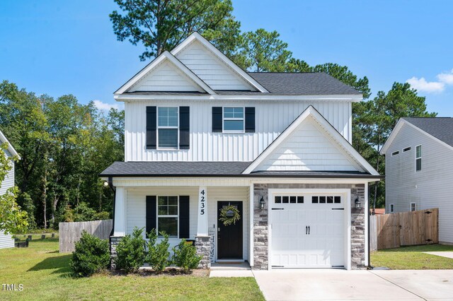 craftsman inspired home with a garage and a front yard