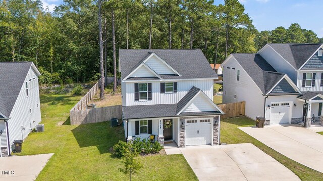 view of front of house featuring a garage, a front lawn, and central air condition unit