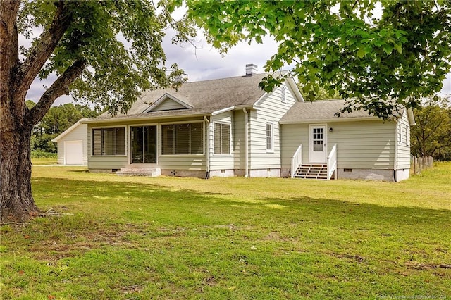 rear view of house with a garage, entry steps, crawl space, and a lawn