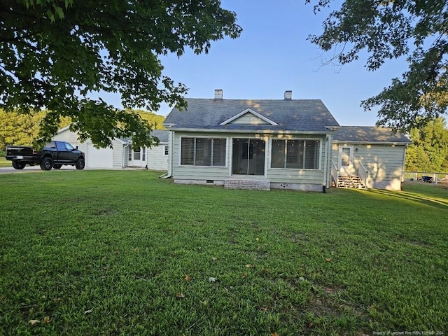 rear view of property with crawl space, a yard, and a chimney