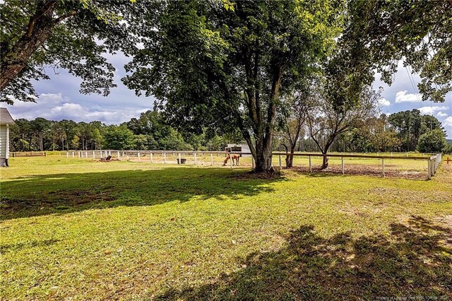 view of yard with a rural view and fence