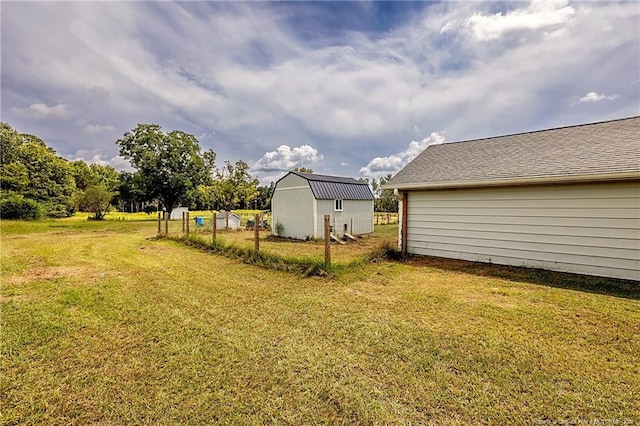 view of yard featuring an outdoor structure and fence