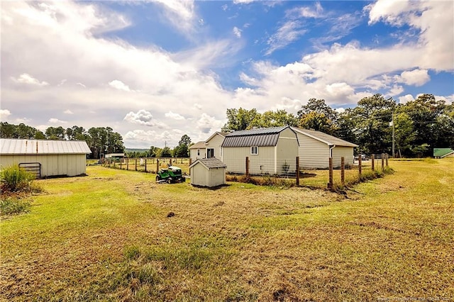 view of yard with an outbuilding, a shed, a rural view, and fence