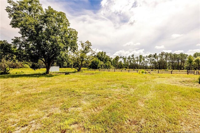 view of yard with a rural view and fence