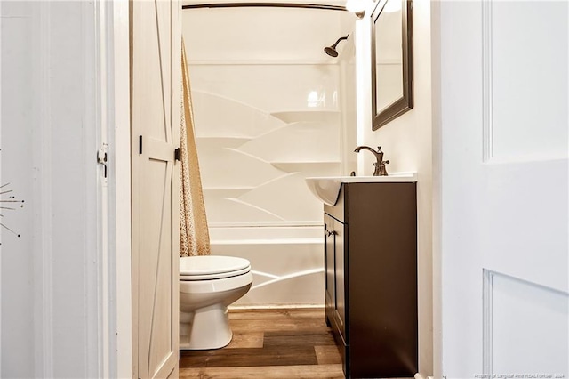 bathroom featuring wood finished floors, vanity, toilet, and shower / bathtub combination