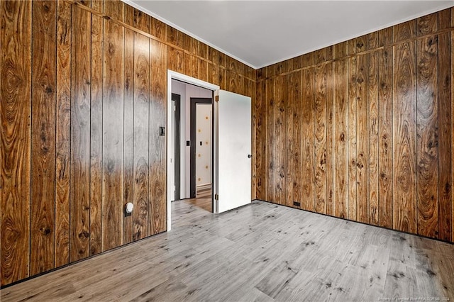 spare room with wood walls and wood finished floors