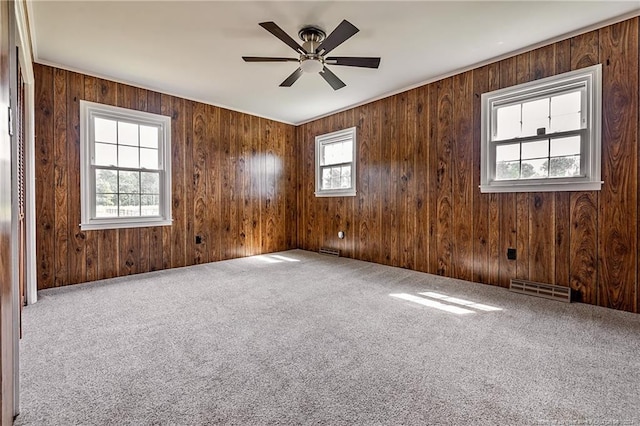 spare room with a healthy amount of sunlight, carpet, visible vents, and ceiling fan