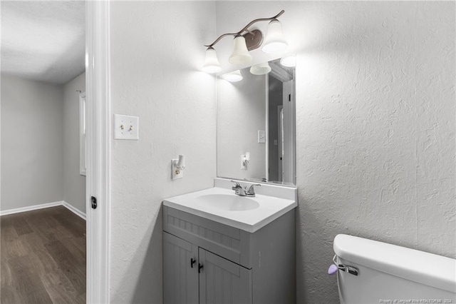 bathroom with hardwood / wood-style floors, toilet, and vanity