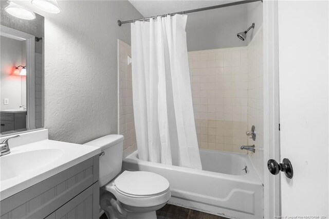 full bathroom featuring vanity, toilet, hardwood / wood-style floors, and shower / bath combo with shower curtain