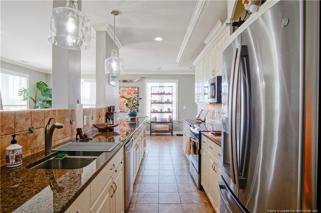 kitchen featuring dark stone counters, white cabinetry, tasteful backsplash, light tile patterned floors, and stainless steel appliances