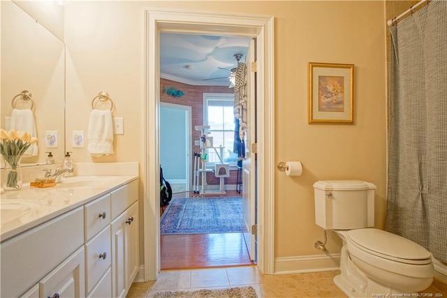 bathroom with tile patterned flooring, vanity, toilet, and crown molding