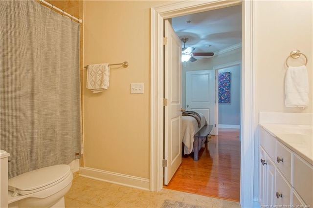 bathroom featuring vanity, crown molding, toilet, tile patterned floors, and ceiling fan