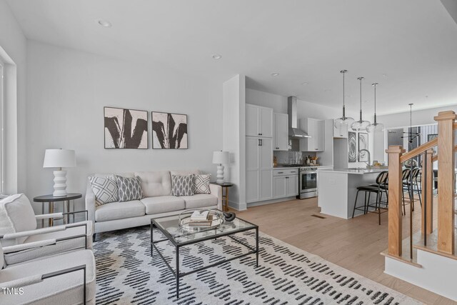 living room with light hardwood / wood-style floors and sink