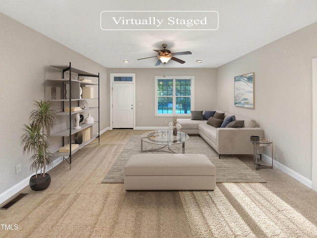 living area with baseboards, visible vents, and ceiling fan