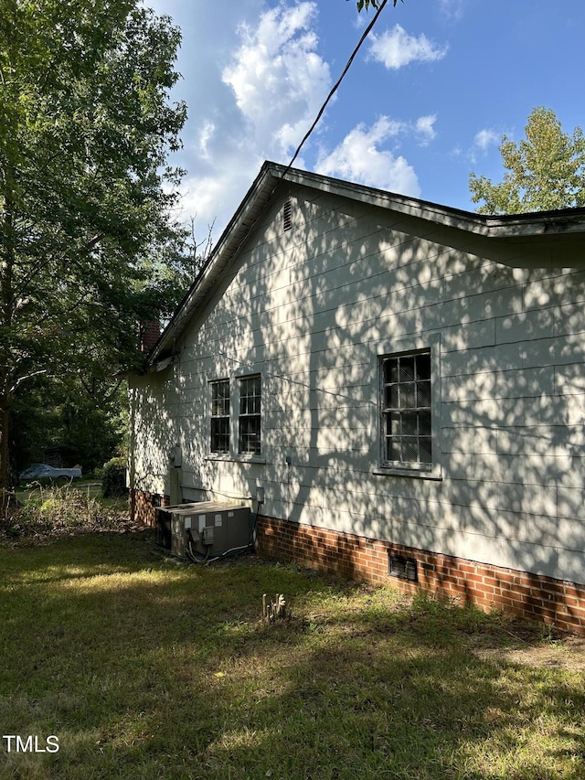 view of side of home featuring a lawn and crawl space