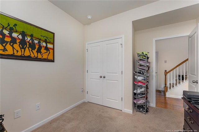 carpeted bedroom featuring baseboards and a closet