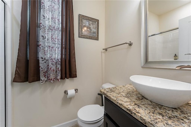 bathroom featuring a shower, toilet, and vanity