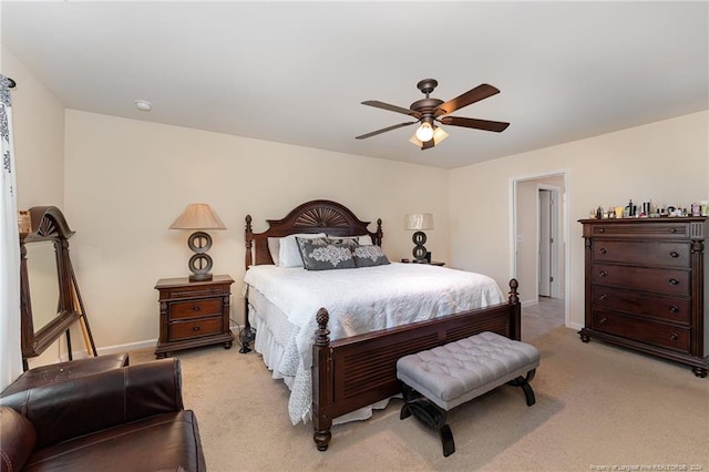 bedroom with light colored carpet, baseboards, and ceiling fan