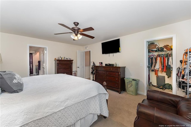 carpeted bedroom with a walk in closet, ceiling fan, and a closet