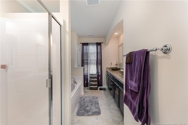 bathroom with tile patterned flooring, vanity, and plus walk in shower