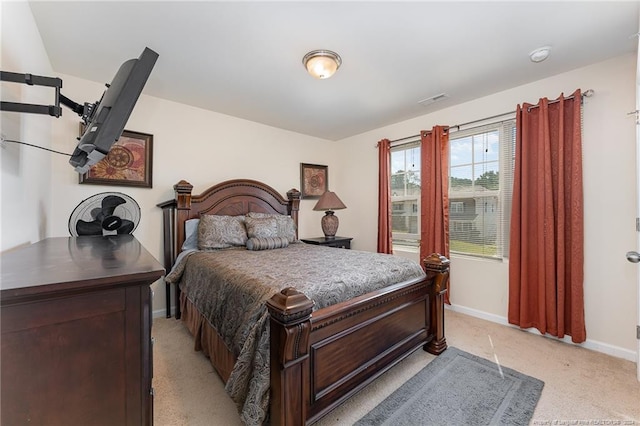 bedroom with visible vents, baseboards, and light carpet