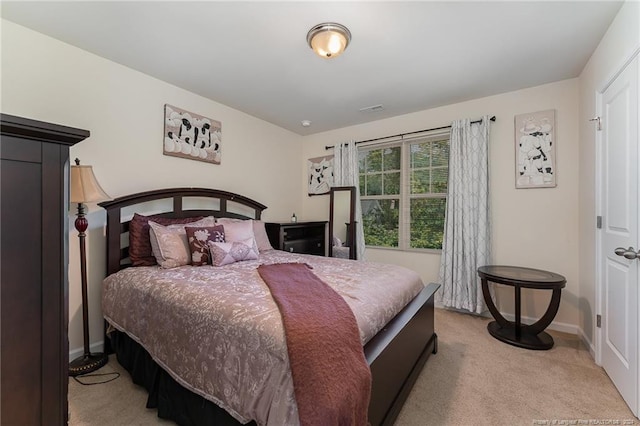 bedroom featuring baseboards, light carpet, and visible vents