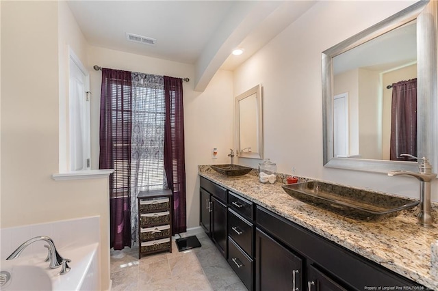 bathroom with vanity, a bath, and tile patterned floors