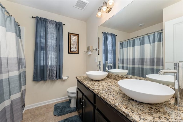 bathroom with a shower with shower curtain, vanity, toilet, and tile patterned floors