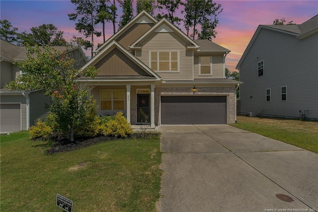 craftsman-style house featuring a garage and a yard