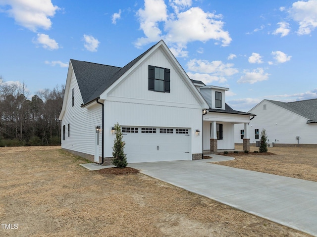 modern farmhouse featuring a garage, covered porch, and a front lawn