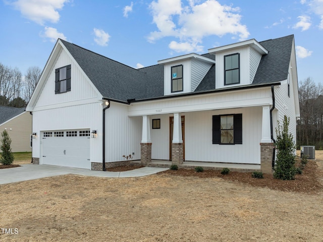 view of front facade featuring a porch, a garage, and central AC unit