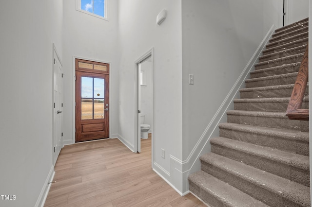 foyer featuring light hardwood / wood-style flooring, a high ceiling, and plenty of natural light