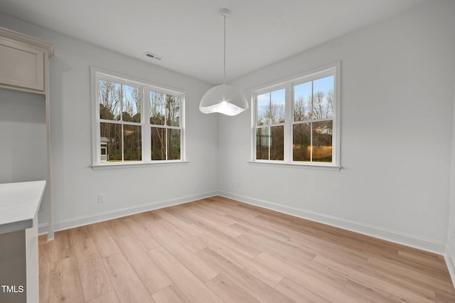 unfurnished dining area with a healthy amount of sunlight and light wood-type flooring