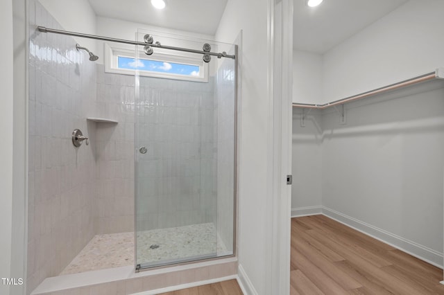 bathroom with hardwood / wood-style flooring and a shower with door