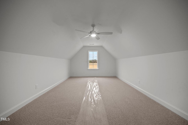 additional living space with vaulted ceiling, light carpet, and ceiling fan