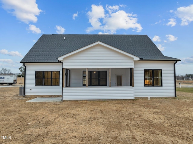 rear view of house featuring a yard, central AC unit, and a patio area