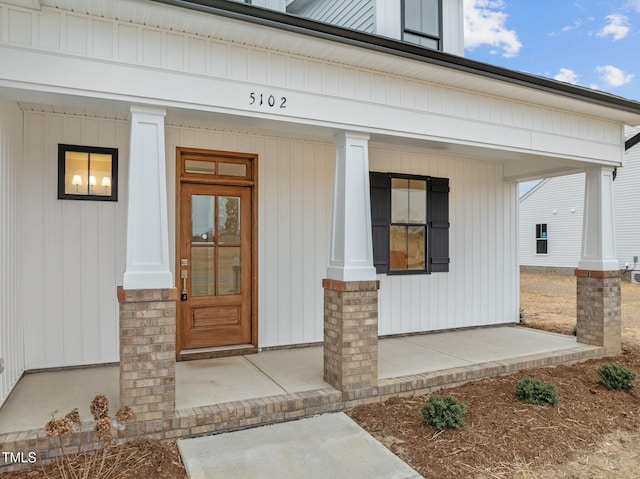 view of exterior entry featuring covered porch