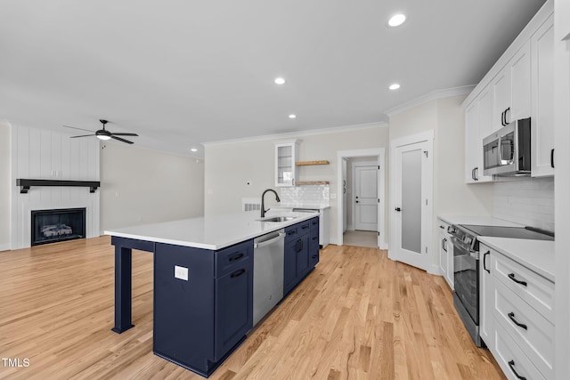 kitchen featuring appliances with stainless steel finishes, blue cabinets, white cabinetry, open shelves, and a sink