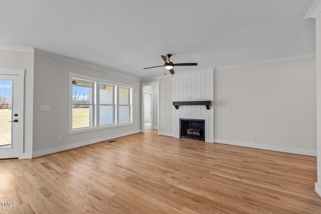 unfurnished living room with a fireplace, light wood-style flooring, and crown molding