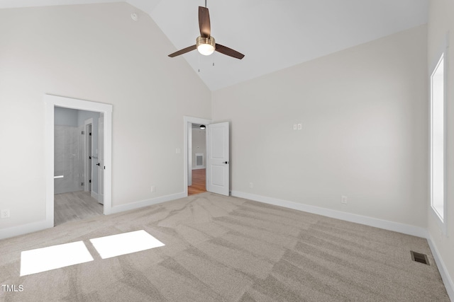 unfurnished bedroom featuring light carpet, high vaulted ceiling, and visible vents